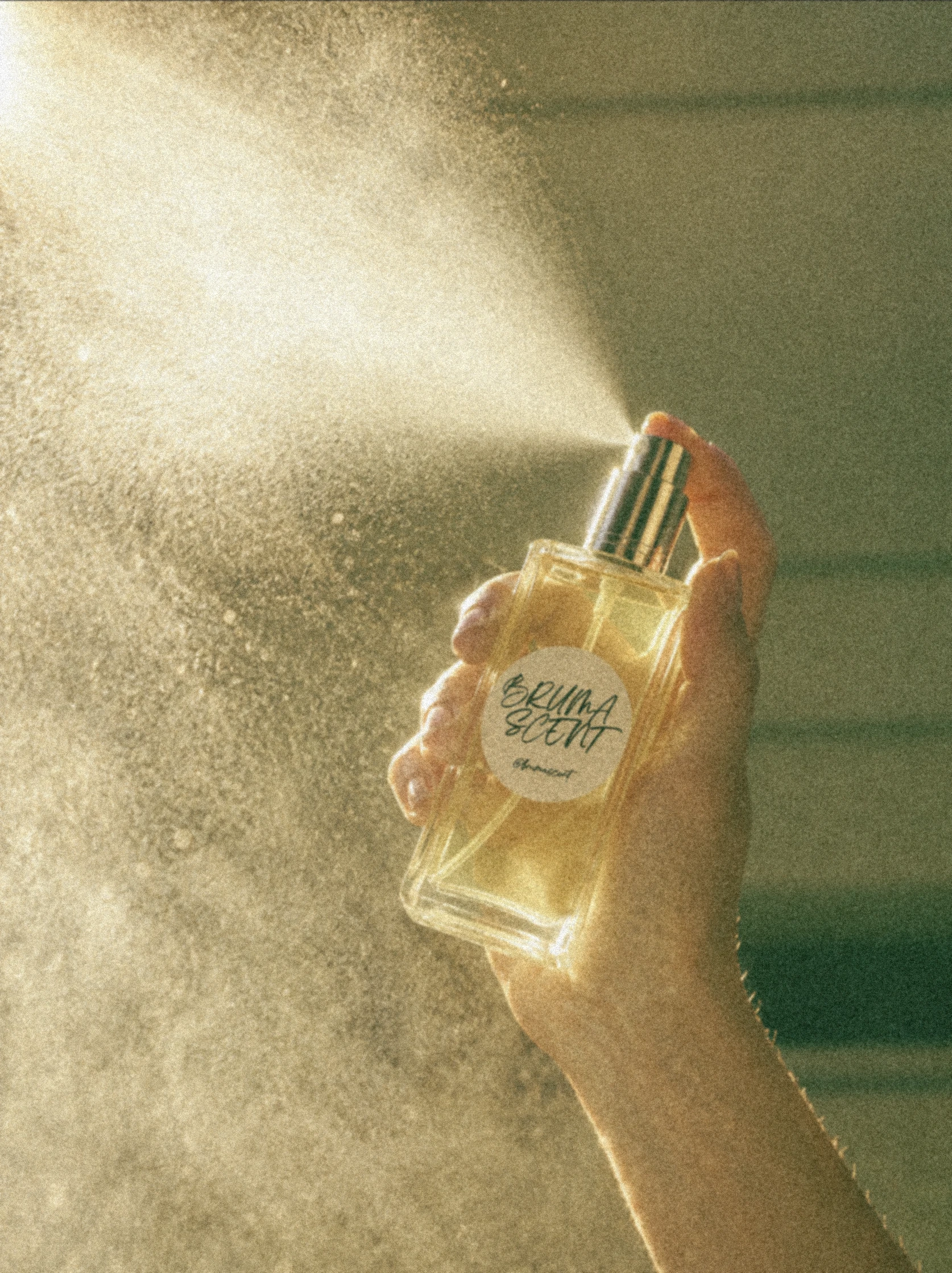 Mano rociando un perfume Bruma Scent a contraluz